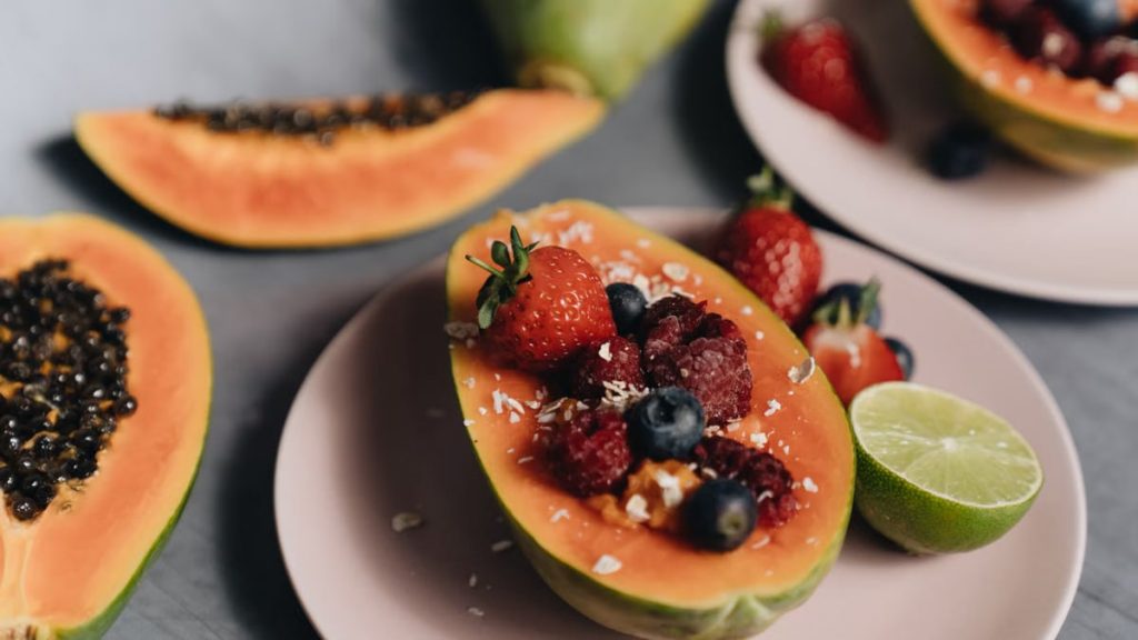 A vibrant photo of a tropical fruit bowl with papaya, berries, and lime, perfect for healthy eating.